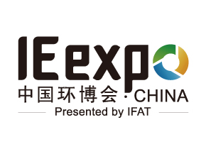 Two men stand on a construction site holding a large blueprint with technical drawings and a visual rendering of a planned building.